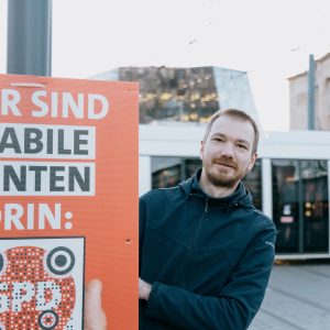 Ludwig Striet mit Wahlplakat "Hier sind stabile Renten drin" in der Freiburger Innenstadt